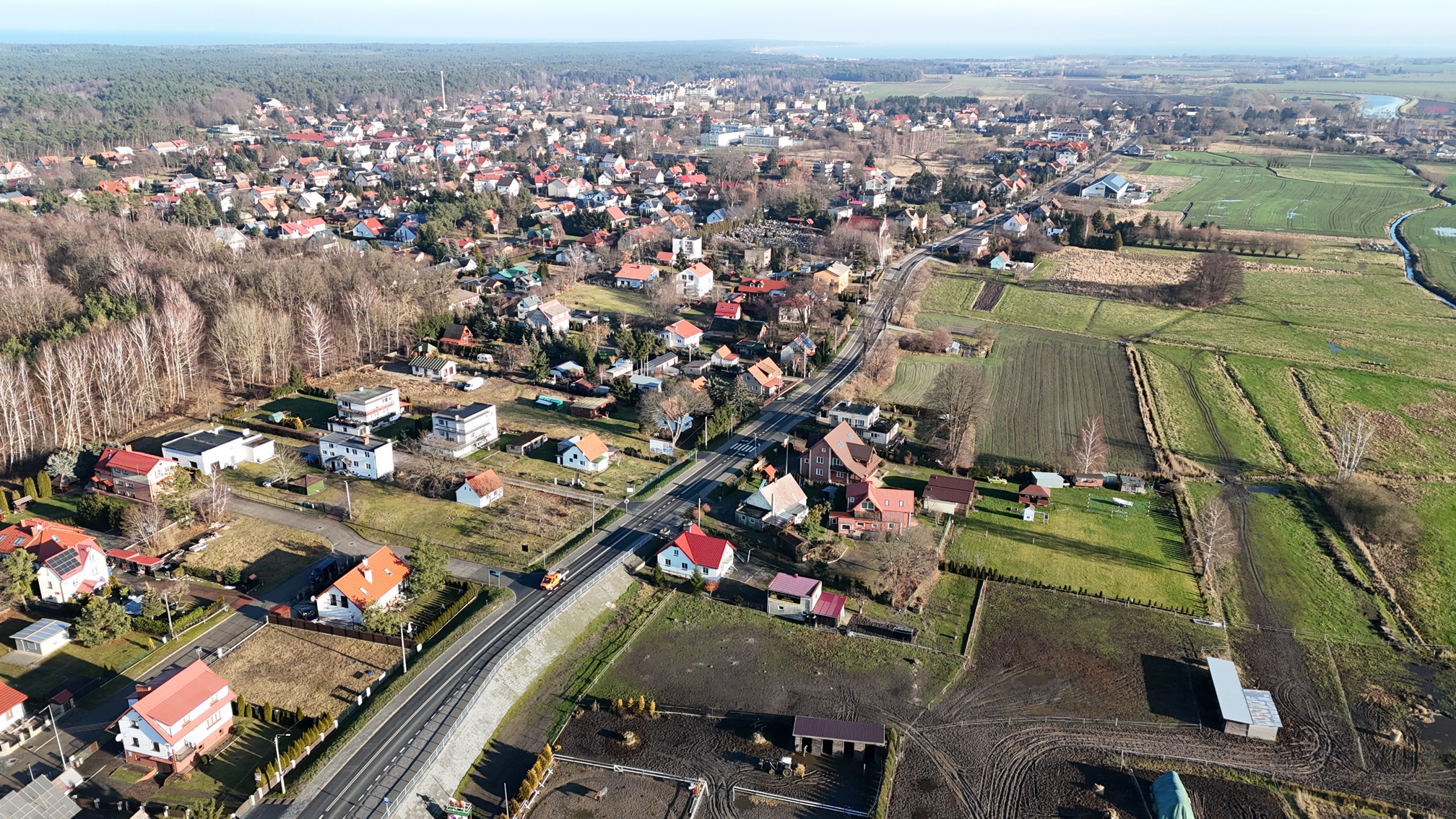 Na zdjęciu przebudowana droga wojewódzka nr 501 w Sztutowie. Nowa nawierzchnia, wybudowane chodniki i zamontowane urządzenia bezpieczeństwa ruchu drogowego. Po obu stronach znajduje się zabudowa miejscowości.